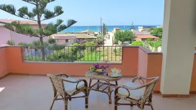 a balcony with a table and chairs and a view of the ocean at Appartamento Citreum in Balestrate