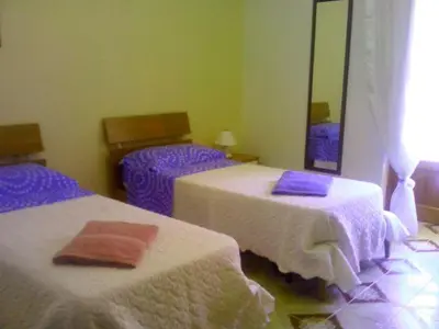 a bedroom with two beds with purple sheets and a mirror at CASA ARENA - Affitti Brevi in Bagheria