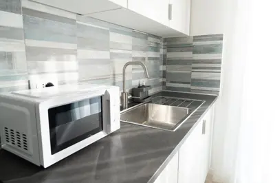 a kitchen with a microwave and a sink at Light Charme, Natural Light Apartment a due passi dalla PIAZZA DUOMO in Terrasini