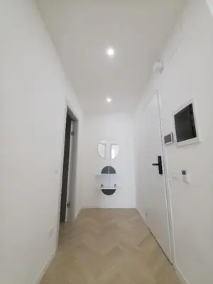 a hallway with a white room with a door and a television at Light Charme, Natural Light Apartment a due passi dalla PIAZZA DUOMO in Terrasini