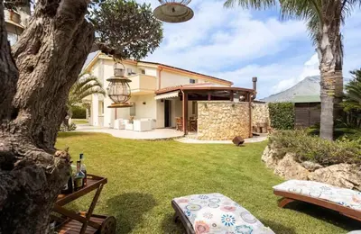 a backyard with a house with a tree and grass at Luxury Hot tub Swimming pool Private pool Wi-Fi BBQ in Castellammare del Golfo