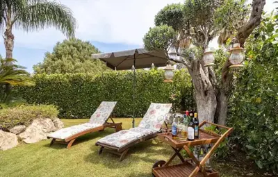 two chairs and a table with bottles of wine at Luxury Hot tub Swimming pool Private pool Wi-Fi BBQ in Castellammare del Golfo