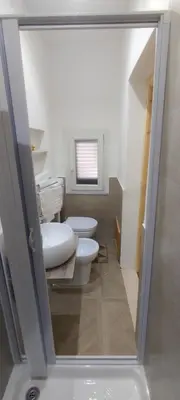 a bathroom with two toilets and a sink at Aspranthouse in Aspra