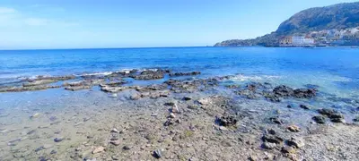 a group of rocks on a beach in the water at Aspranthouse in Aspra