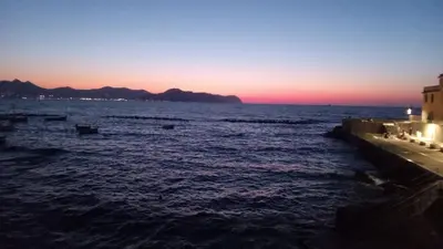 a sunset over the ocean with boats in the water at Aspranthouse in Aspra