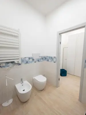 a white bathroom with a toilet and a bidet at Light Charme, Sea Light Apartment a due passi dalla PIAZZA DUOMO in Terrasini