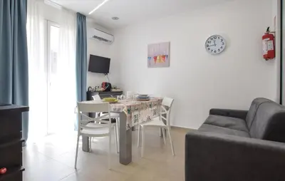 a living room with a table and chairs and a clock at Awesome Apartment In Capaci With Wifi in Capaci