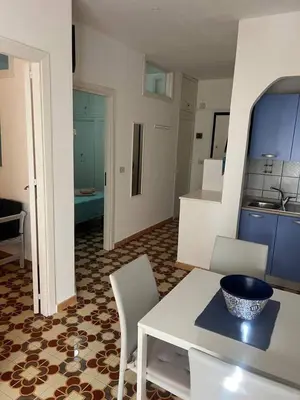 a kitchen and living room with a table and chairs at Blue Sea Apartment in Isola delle Femmine