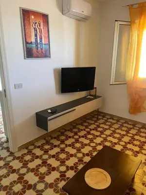 a living room with a flat screen tv on a wall at Blue Sea Apartment in Isola delle Femmine