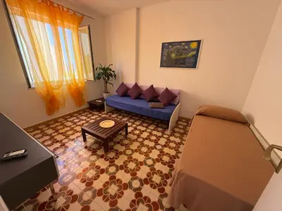 a living room with a blue couch and a table at Blue Sea Apartment in Isola delle Femmine