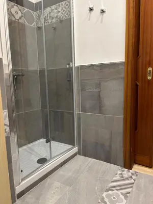 a shower with a glass door in a bathroom at House La Cantinetta in Palermo