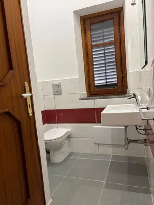 a bathroom with a toilet and a sink and a window at House La Cantinetta in Palermo