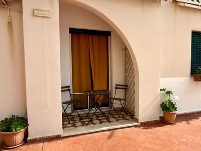 a balcony with chairs and a table in a building at Emma's Beach Apartment in Isola delle Femmine