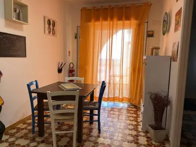 a dining room with a table and chairs and a window at Emma's Beach Apartment in Isola delle Femmine
