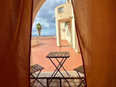 a table and two chairs on a balcony at Emma's Beach Apartment in Isola delle Femmine