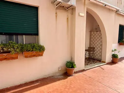 a building with potted plants on the side of it at Emma's Beach Apartment in Isola delle Femmine