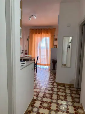 a kitchen with a tile floor and a kitchen with a table at Emma's Beach Apartment in Isola delle Femmine