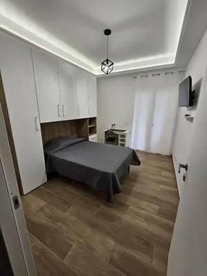 a bedroom with a bed and a wooden floor at Palermo Francia in Palermo