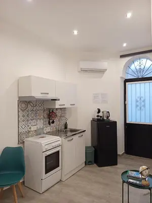 a kitchen with white cabinets and a black refrigerator at Diana ai Quattro Canti - centro storico Palermo in Palermo