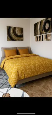 a bed with a yellow comforter in a bedroom at Dagma Spa Home Sicilia in Carini