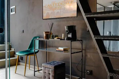 a room with a table and a green chair at Cattedrale Suite in Palermo