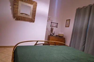 a bedroom with a bed with a green blanket on it at Love nest cathedral ,in the heart of the city in Palermo