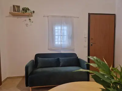 a blue couch in a living room with a window at Love nest cathedral ,in the heart of the city in Palermo