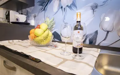 a table with a bowl of fruit and a bottle of wine at Villa degli Ulivi in Partinico