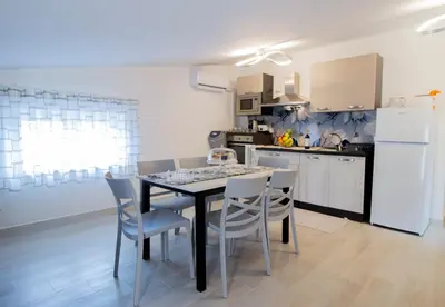 a kitchen with a dining room table and chairs at Villa degli Ulivi in Partinico