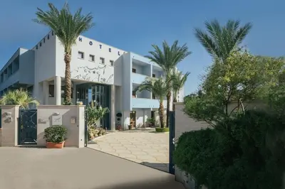 a building with palm trees in front of it at Hotel Costa Azul in Balestrate