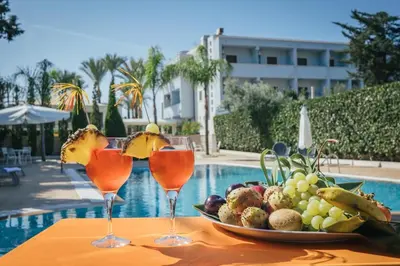 a plate of fruit on a table next to a pool at Hotel Costa Azul in Balestrate