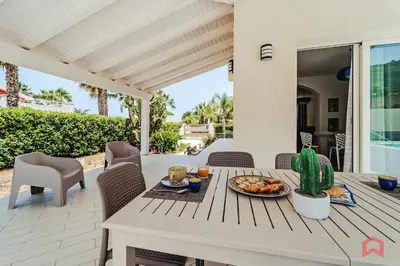 a table with a plate of food on a patio at Villa with private Pool in Castellammare dei Golfo in Castellammare del Golfo