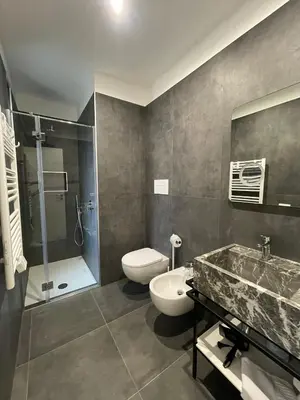 a bathroom with a toilet and a sink and a shower at Villa Tosto in Castelluzzo