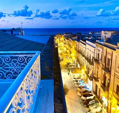 a view from a balcony of a city at night at Palazzo 700 in Castellammare del Golfo