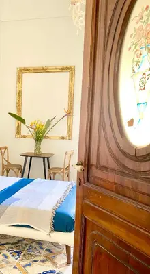 a bedroom with a bed and a wooden door at Palazzo 700 in Castellammare del Golfo