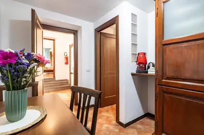 a dining room with a vase of flowers on a table at GuestHost - La Maison Real Palermo in Palermo