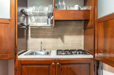 a kitchen with a sink and a stove at GuestHost - La Maison Real Palermo in Palermo