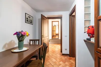 a dining room with a table and a vase of flowers at GuestHost - La Maison Real Palermo in Palermo