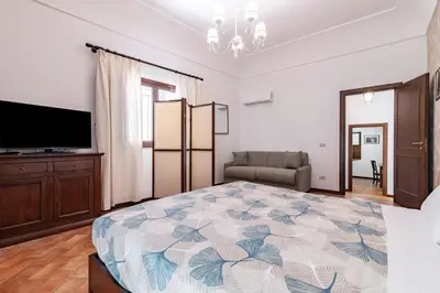 a bedroom with a large bed and a flat screen tv at GuestHost - La Maison Real Palermo in Palermo