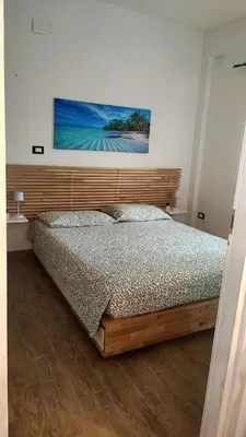 a bedroom with a bed with a wooden headboard at Heaven House Sicily in Carini