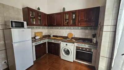 a kitchen with a white refrigerator and a washing machine at Villa del Faro, Capo Zafferano in Santa Flavia