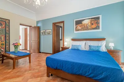 a bedroom with a blue bed and a table at GuestHost - Central Apartment Palermo in Palermo