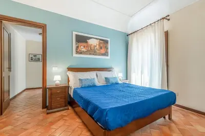 a blue bedroom with a bed and a window at GuestHost - Central Apartment Palermo in Palermo