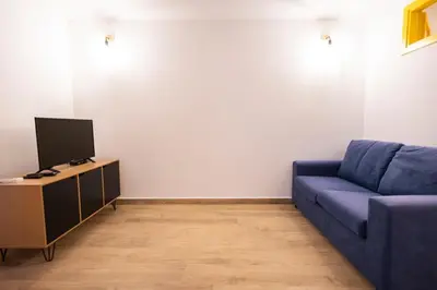 a living room with a blue couch and a tv at Flat in center 2 in Palermo