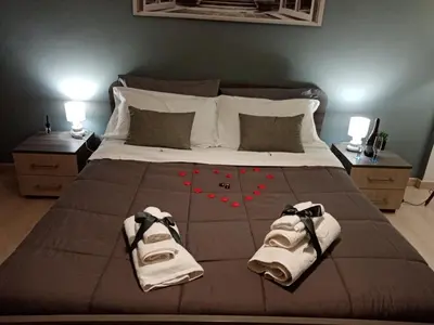 a bed with two towels and red flowers on it at Dante091 in Palermo