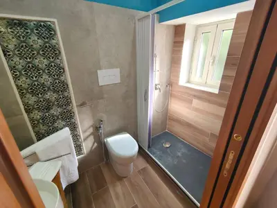 a small bathroom with a toilet and a shower at Atypical Rooms in Palermo