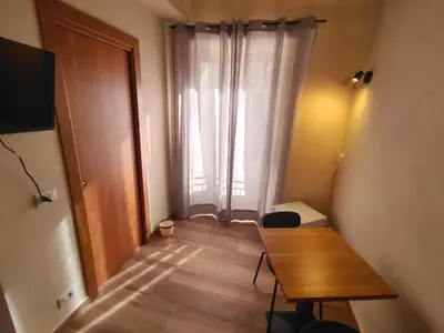 a small room with a table and a window at Atypical Rooms in Palermo