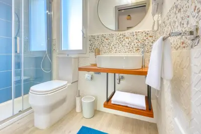 a bathroom with a toilet and a sink and a mirror at VFH Blue Breeze holiday home in Porticello