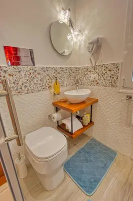 a bathroom with a white toilet and a sink at VFH Blue Breeze holiday home in Porticello