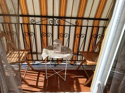 a balcony with two chairs and a table with a computer on it at La Casa del Sole in Corleone